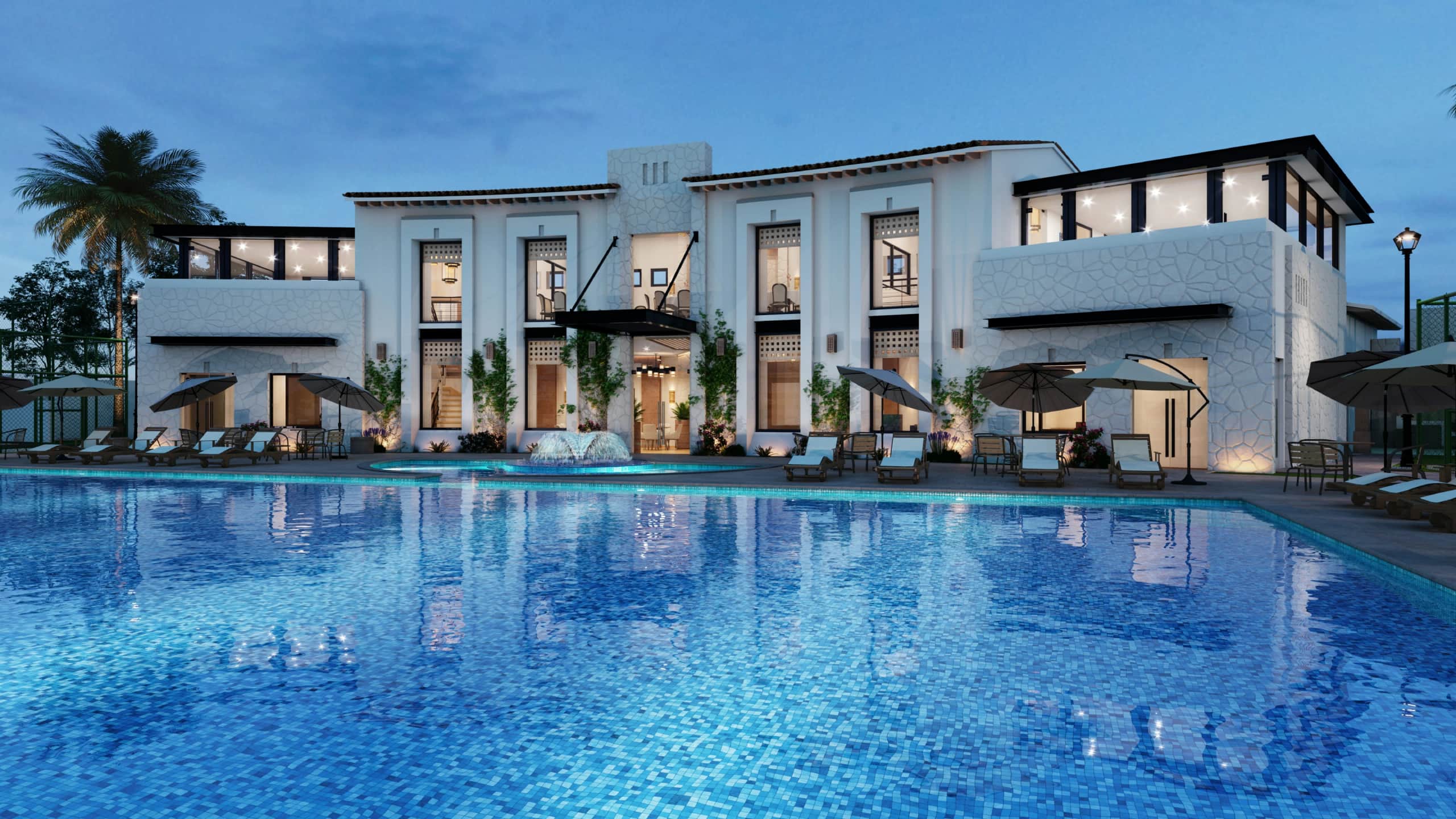 Luxury villa with illuminated swimming pool and lounge chairs at dusk